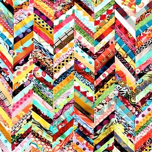 Colorful herringbone quilt with many patterns of fabric pointing downwards